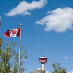 Canadian flag with Calgary tower seen from central memorial park